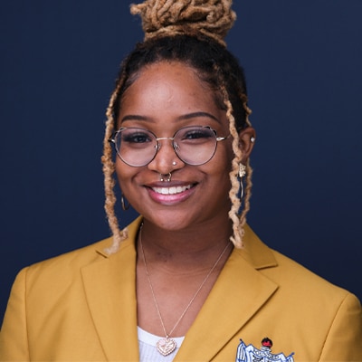 a woman wearing glasses and smiling at the camera