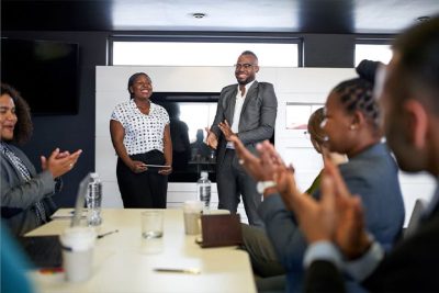 A Group Of People Standing Around A Table