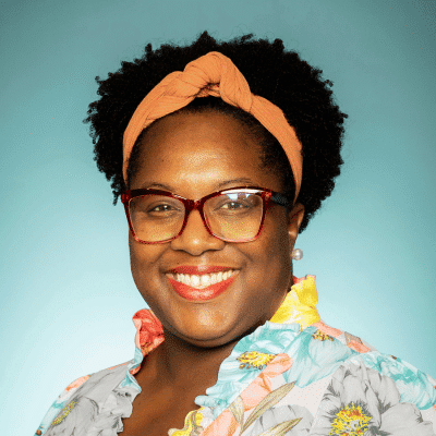 a person wearing glasses and smiling at the camera