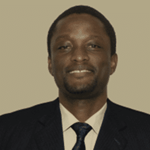 A Man Wearing A Suit And Tie Smiling At The Camera