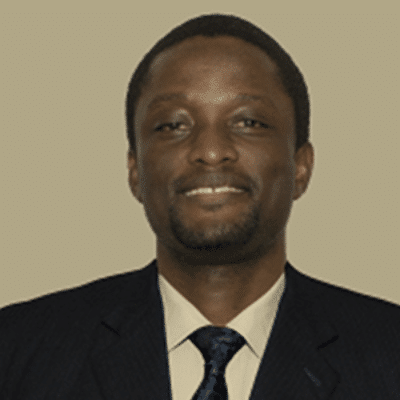 a man wearing a suit and tie smiling at the camera