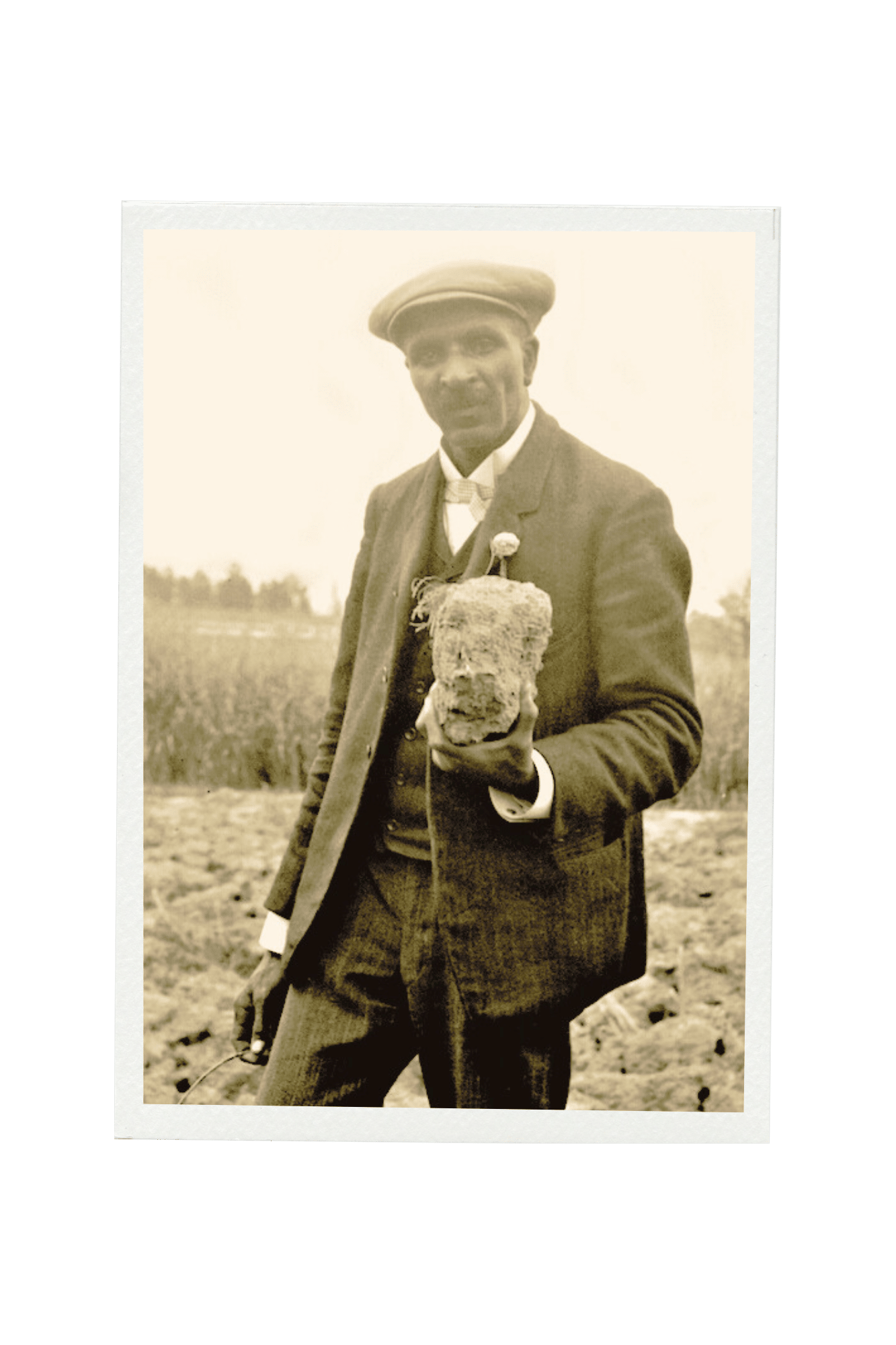 a vintage photo of George Washington Carver holding a sign posing for the camera